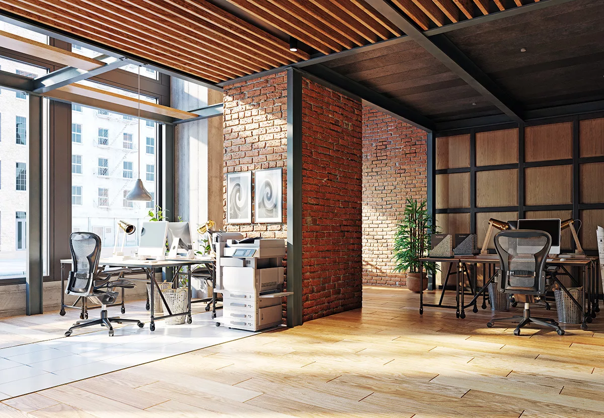 The interior of a contemporary commercial office building with hardwood floors and brick walls