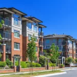 An apartment complex after curb appeal renovations, with neat landscaping, a brick exterior, and fresh paint