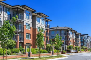 An apartment complex after curb appeal renovations, with neat landscaping, a brick exterior, and fresh paint