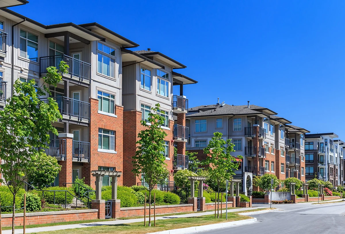 An apartment complex after curb appeal renovations, with neat landscaping, a brick exterior, and fresh paint