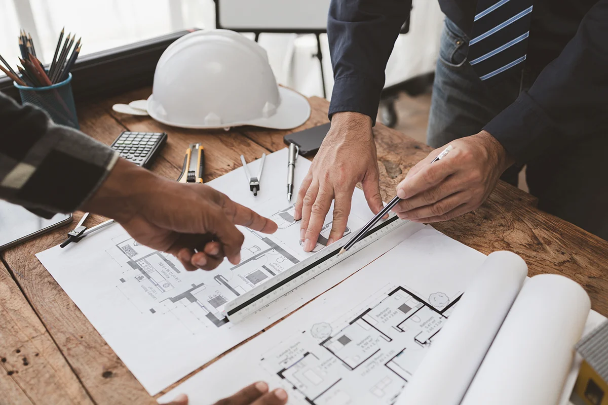 A construction team goes over a pre-construction checklist for a commercial remodeling project at a desk