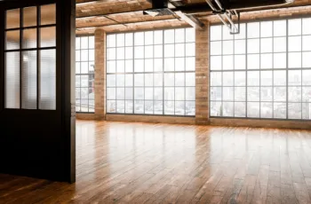 The interior of a modern commercial building after a commercial remodeling project, with brick walls, large windows, and hardwood floors