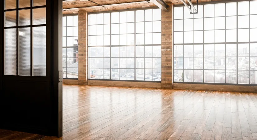 The interior of a modern commercial building after a commercial remodeling project, with brick walls, large windows, and hardwood floors