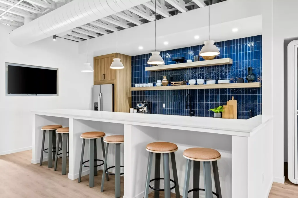 Interior of remodeled kitchen with blue tile walls, long island, appliances, and decor