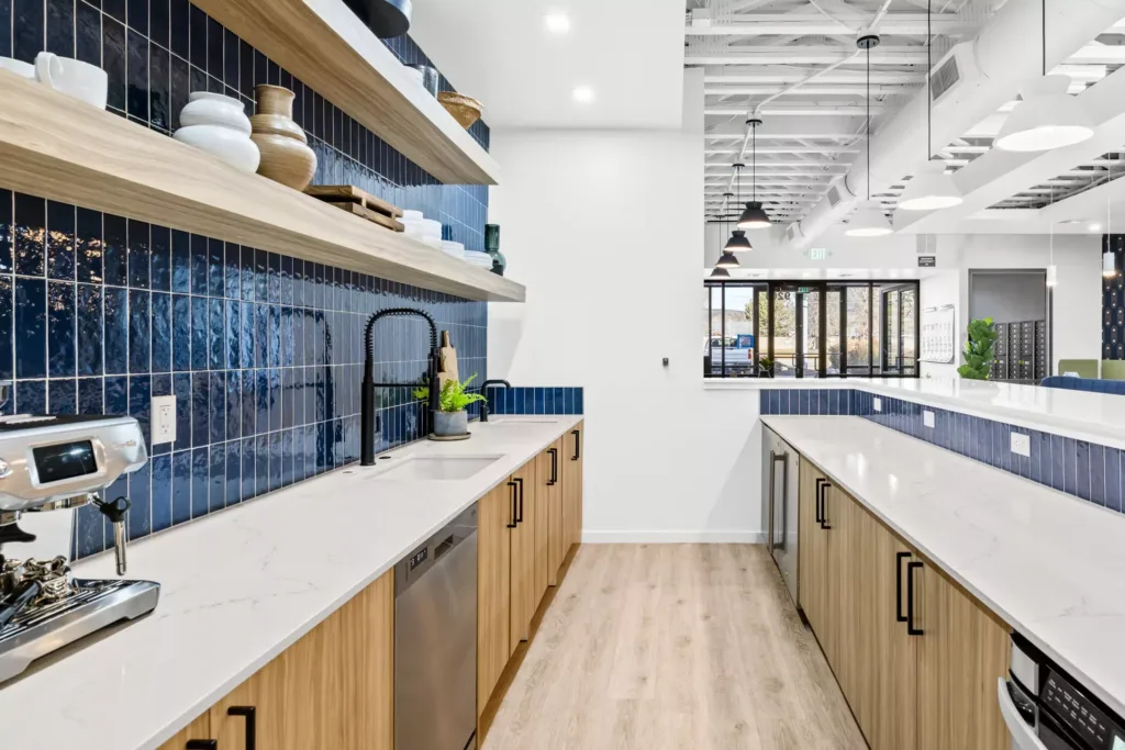 Interior of remodeled kitchen with blue tile walls, long island, appliances, and decor