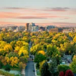 Bird's eye view of Boise, Idaho at sunset, with vibrant green trees and colorful houses, showing the concept of the best places in Idaho to build a new home