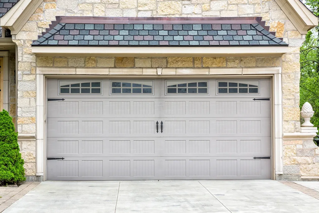 A house with a stone exterior and a newly renovated garage door